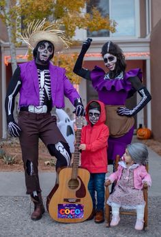 three people dressed up as skeletons and skeleton characters with a guitar in front of a house