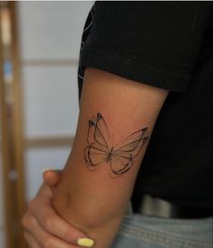 a woman's arm with a butterfly tattoo on the left side of her arm