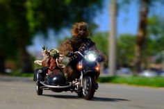 a person on a motorcycle with a baby yoda riding in the back