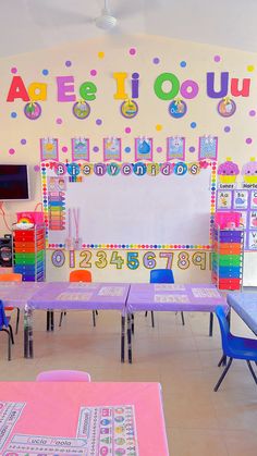 there are many tables and chairs in the classroom with colorful decorations on the wall behind them