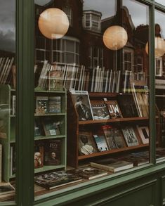 a book store with many books on display in the window and behind it are two lamps