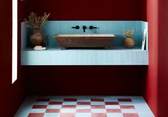 a bathroom with red and blue tiles on the walls