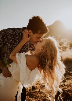 a man and woman kissing in the desert