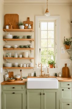 a kitchen filled with lots of green cupboards and white dishes on top of wooden shelves