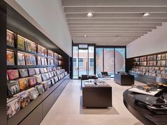 a large room filled with lots of books on shelves next to a wall full of records