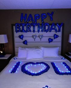 a bed with blue lights on it and the words happy birthday spelled out in front