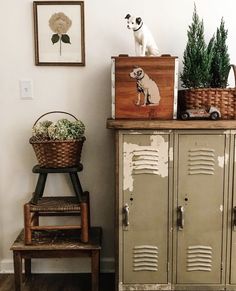 an old locker with some plants on top and a dog figurine sitting on top