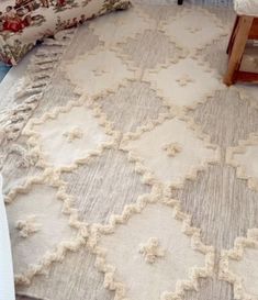 a white rug sitting on top of a bed next to pillows