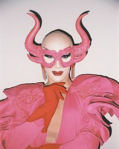 a woman wearing pink and red with horns on her head