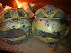 two large yellow balls sitting next to each other on top of a wooden table covered in newspaper