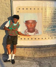 a man is standing in front of a poster with a picture of him on it