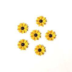 five yellow flowers with black centers on a white background