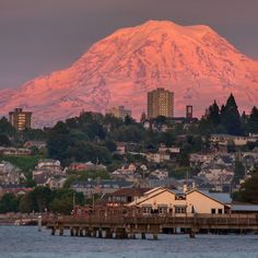 a large snow covered mountain in the background with houses and buildings on it's sides