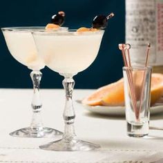 two glasses filled with drinks sitting on top of a table