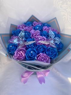 a bouquet of blue and purple roses with butterflies