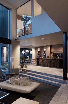 a living room filled with furniture next to a kitchen and an open floor plan area