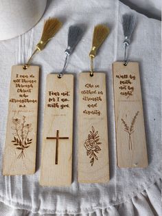 three wooden bookmarks with different designs and words on them, along with two brushes