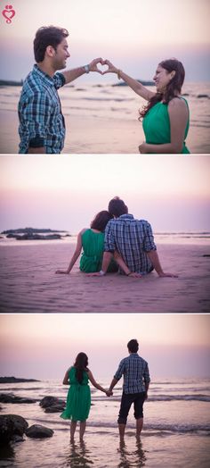 two people sitting on the beach with their hands in each other's heart shape