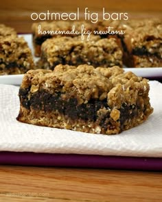 several pieces of granola bars on a white napkin next to another plate with one slice cut in half