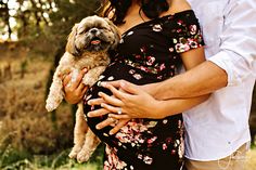 a pregnant woman holding a dog in her arms