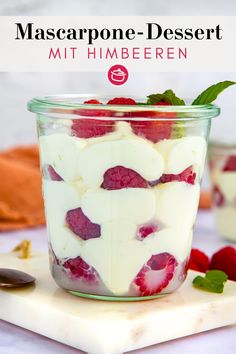 a dessert in a jar with raspberries and cream