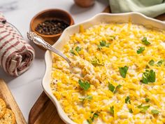 a casserole dish filled with cheese and garnished with cilantro