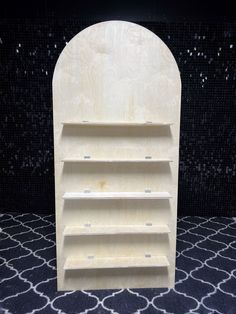 a wooden book shelf sitting on top of a rug