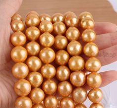 a hand holding a bunch of golden pearls