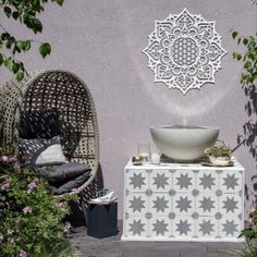 an outdoor area with two chairs, a table and a bowl on top of it