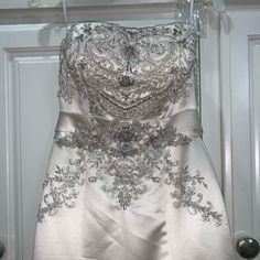 a wedding dress hanging on a door with beading and sequins around it