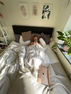 a woman laying in bed with an apple laptop