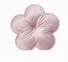 a pink flower shaped pillow sitting on top of a white table