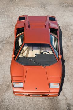 an orange sports car parked in a parking lot