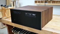 a wooden box sitting on top of a table next to wine racks and bottles in a room