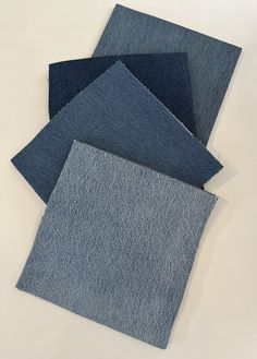 four pieces of blue fabric laid on top of each other in different sizes and colors