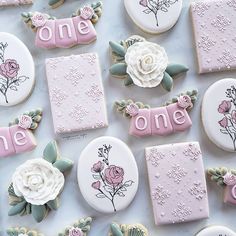 some decorated cookies are on a table with flowers and one is for the first time