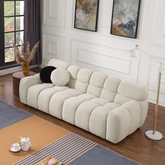 a white couch sitting on top of a hard wood floor next to a coffee table