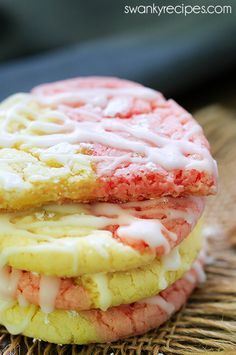 two cookies with white icing and red sprinkles are stacked on top of each other