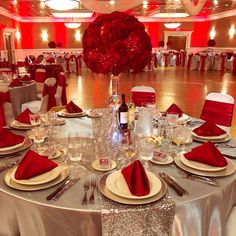 the table is set with silver and red linens