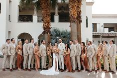 a group of people standing next to each other in front of a building with palm trees