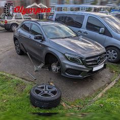 two cars parked in a parking lot next to each other and one is being towed by a tow truck