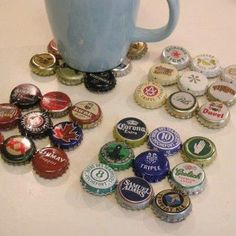 a blue mug sitting on top of a table filled with bottle caps