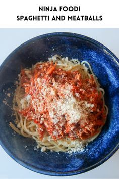 a blue bowl filled with spaghetti and meatballs