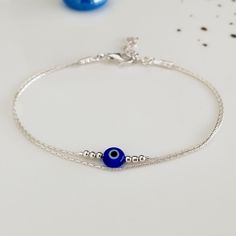 "Minimalist, wearable and delicate sterling 925 silver bracelet of two strands with colored greek evil eye charms. Length: from 5,5\" to 8\" with 1\" (2.5cm) 925 sterling silver extensor chain. Width: 2mm 925 sterling silver beads and 6mm evil eye charms. Chain width: 0,66 mm. Handmade in Spain. Ideal for a gift to silver jewelry lovers. All our products are presented in an organza bag. ♡ Made with love in Valencia ♡ ----------------------------- Discover the NICTE collection here: https://www.etsy.com/shop/NicteShop ♡ Gemstone bracelets > https://www.etsy.com/es/shop/NicteShop?section_id=32205467 * Moonstone jewelry > https://www.etsy.com/es/shop/NicteShop?section_id=32321209 ♡ Gold bracelets > https://www.etsy.com/es/shop/NicteShop?section_id=27642168 * Silver bracelets > https://www.ets Silver Bracelets Evil Eye, Minimalist Bracelet Silver, Evil Eye Jewelry Bracelet, Evil Eye Bracelet Silver, Evil Eye Bracelet Gold, Silver Evil Eye Bracelet, Greek Evil Eye, Bracelet Cordon, Silver Eye