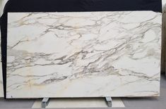 a large white marble slab sitting on top of a metal stand