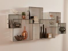 a wall mounted shelf filled with vases and books