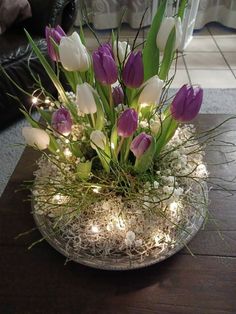 a glass bowl filled with purple and white flowers