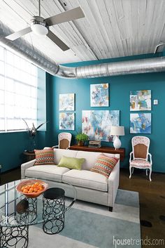 a living room with blue walls and white furniture