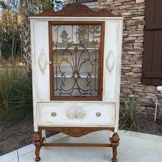 an old china cabinet is painted white and brown