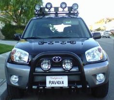 the front end of a gray toyota rav4 with four lights on it's headlamps